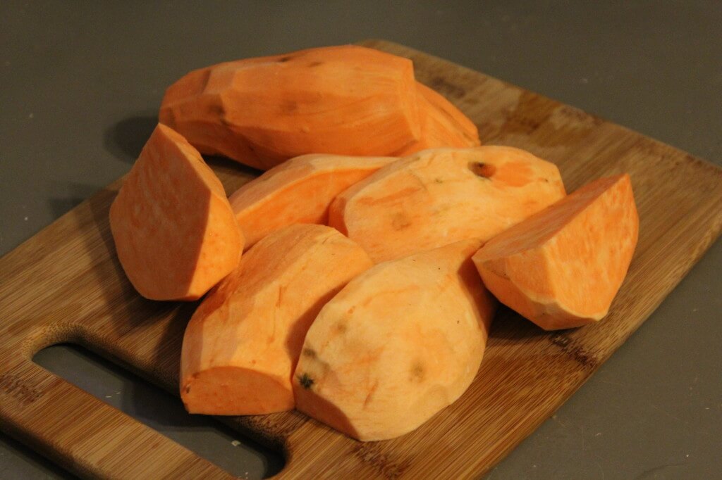 sweet potatoes peeled and cut on cutting board