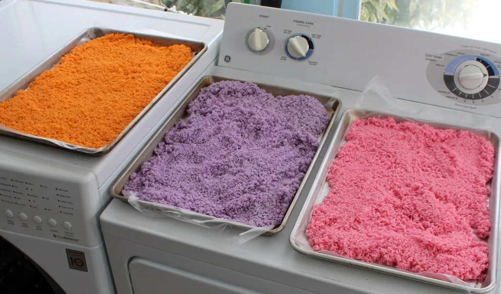 orange, purple and pink rice on separate baking pans