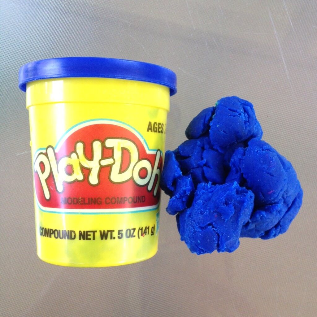 blue play doh beside the play doh container