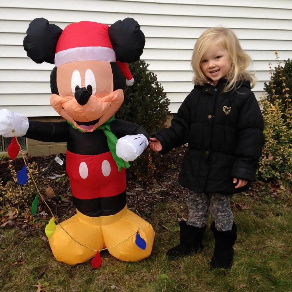 little girl next to inflatable christmas Mickey