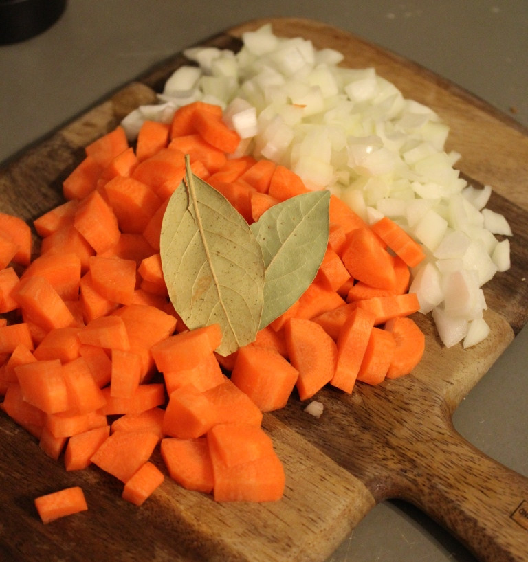 carrots, onion and bay leaves on cutting board
