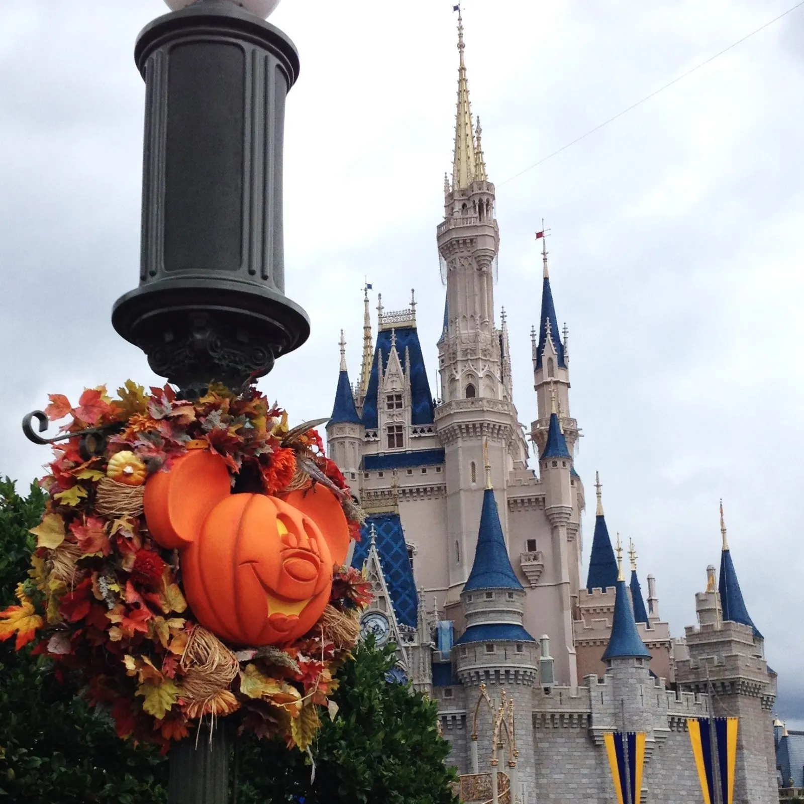 halloween decor on lamp post with cinderella's castle in the background