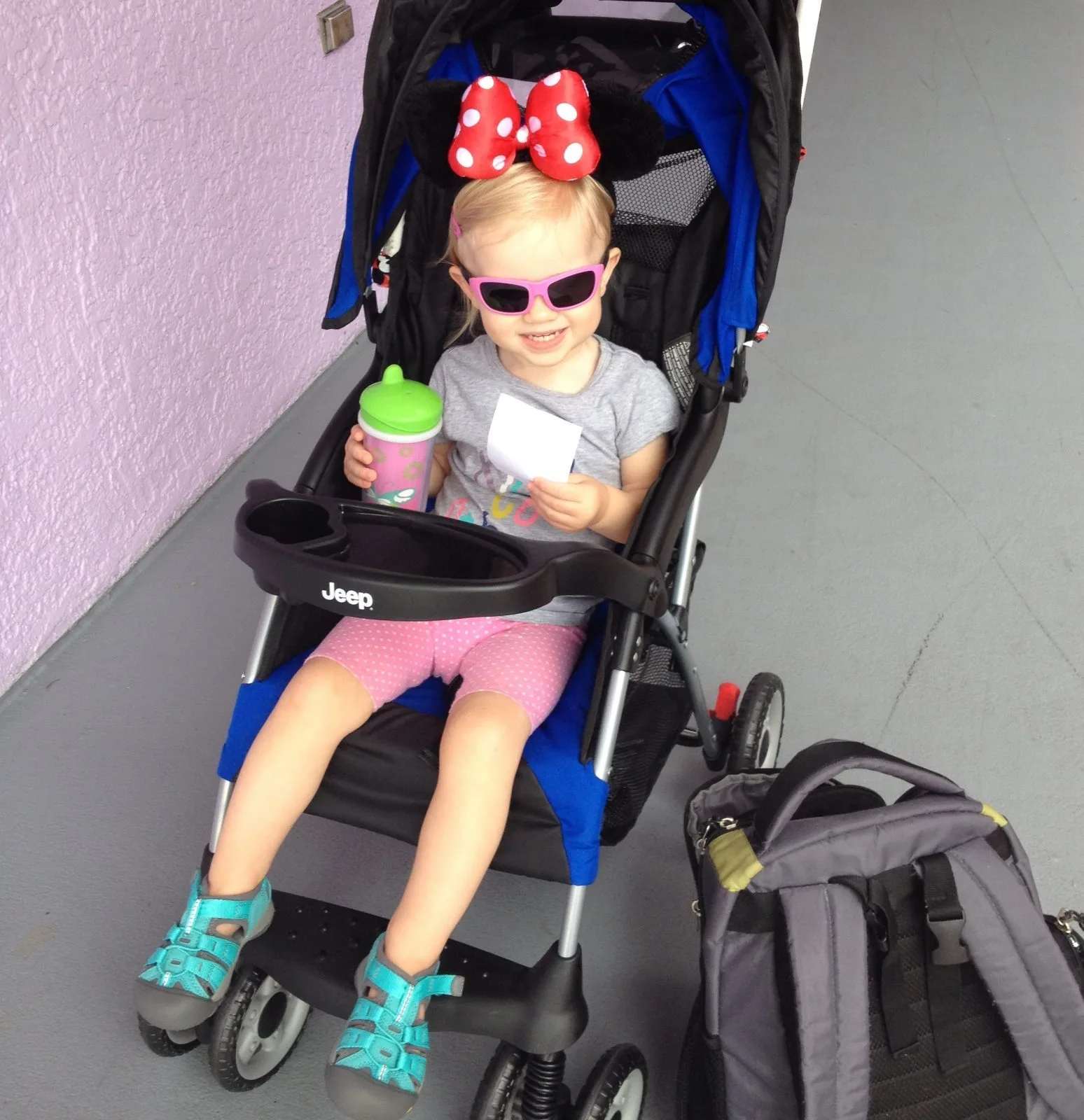 little girl with minnie ears sitting in a stroller