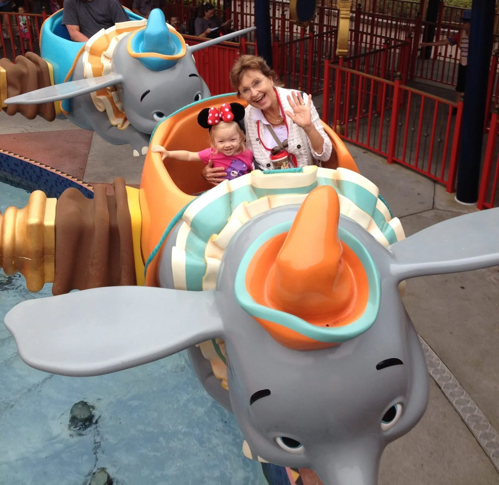 little girl and grandmother riding dumbo ride at magic kingdom