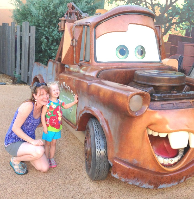 mom and daughter posing with Mater from Cars