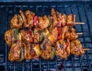 chicken with vegetables shish keabobs on a grill 