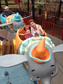 woman and child smiling, riding in Dumbo ride