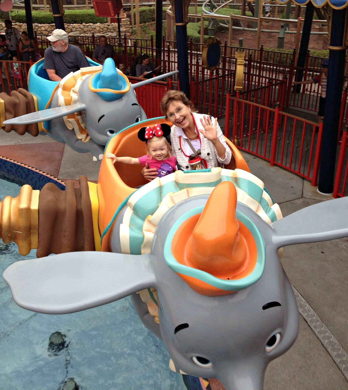 woman and child smiling, riding in Dumbo ride