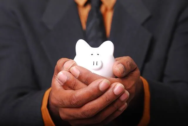 man holding a small piggy bank