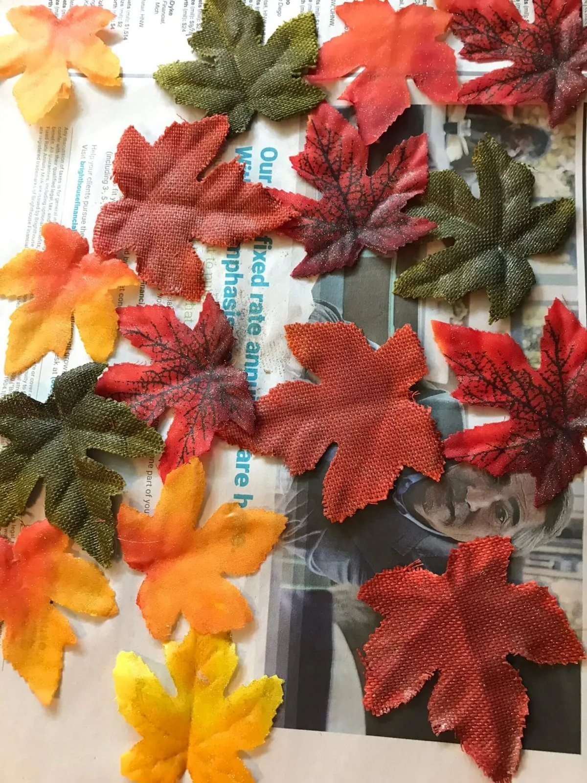 fake leaves spread across newspaper