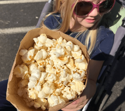 little girl with a bag of popcorn