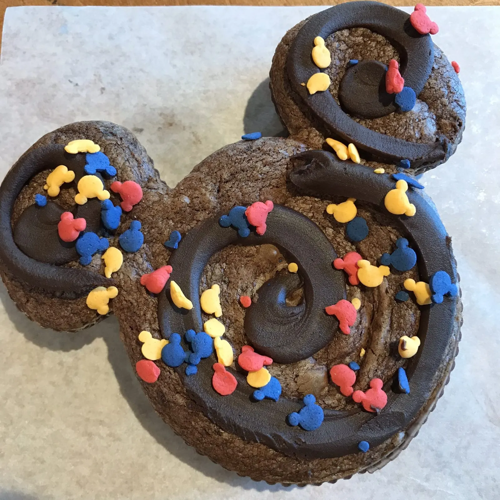 brownie treat in the shape of mickey mouse with mickey mouse sprinkles