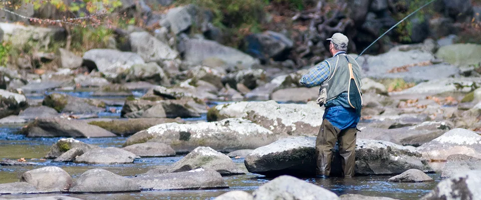 man fly-fishing in a stream