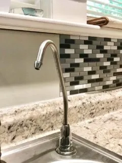 vinyl tiles being applied to kitchen backsplash