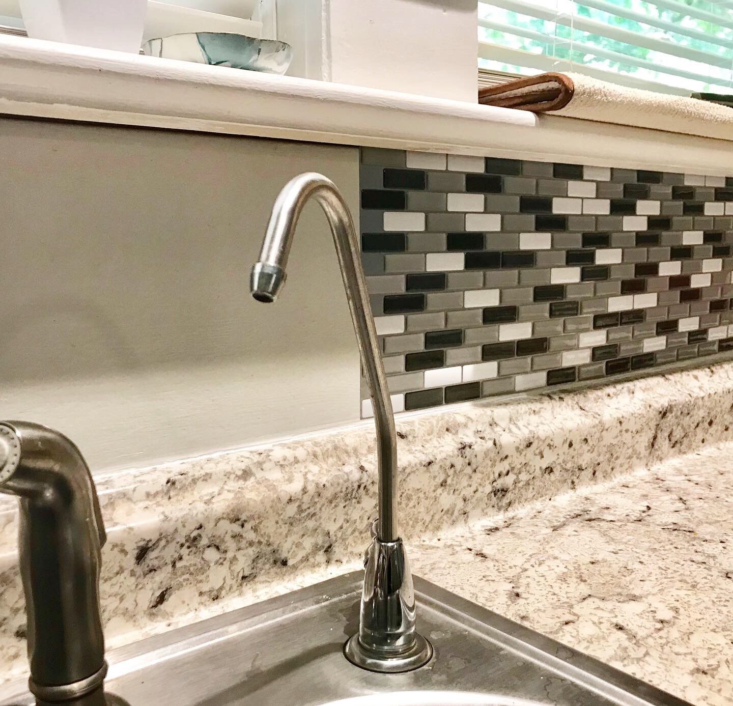 kitchen sink with partial peel and stick back splash put up