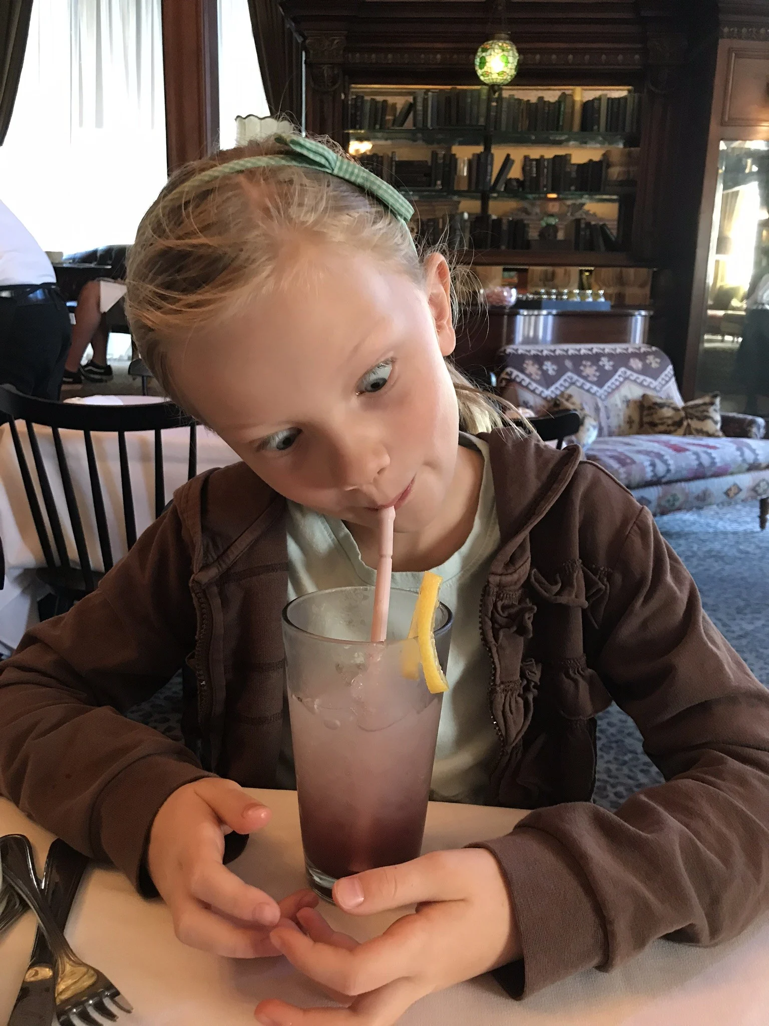 little girl drinking a blueberry lemonade
