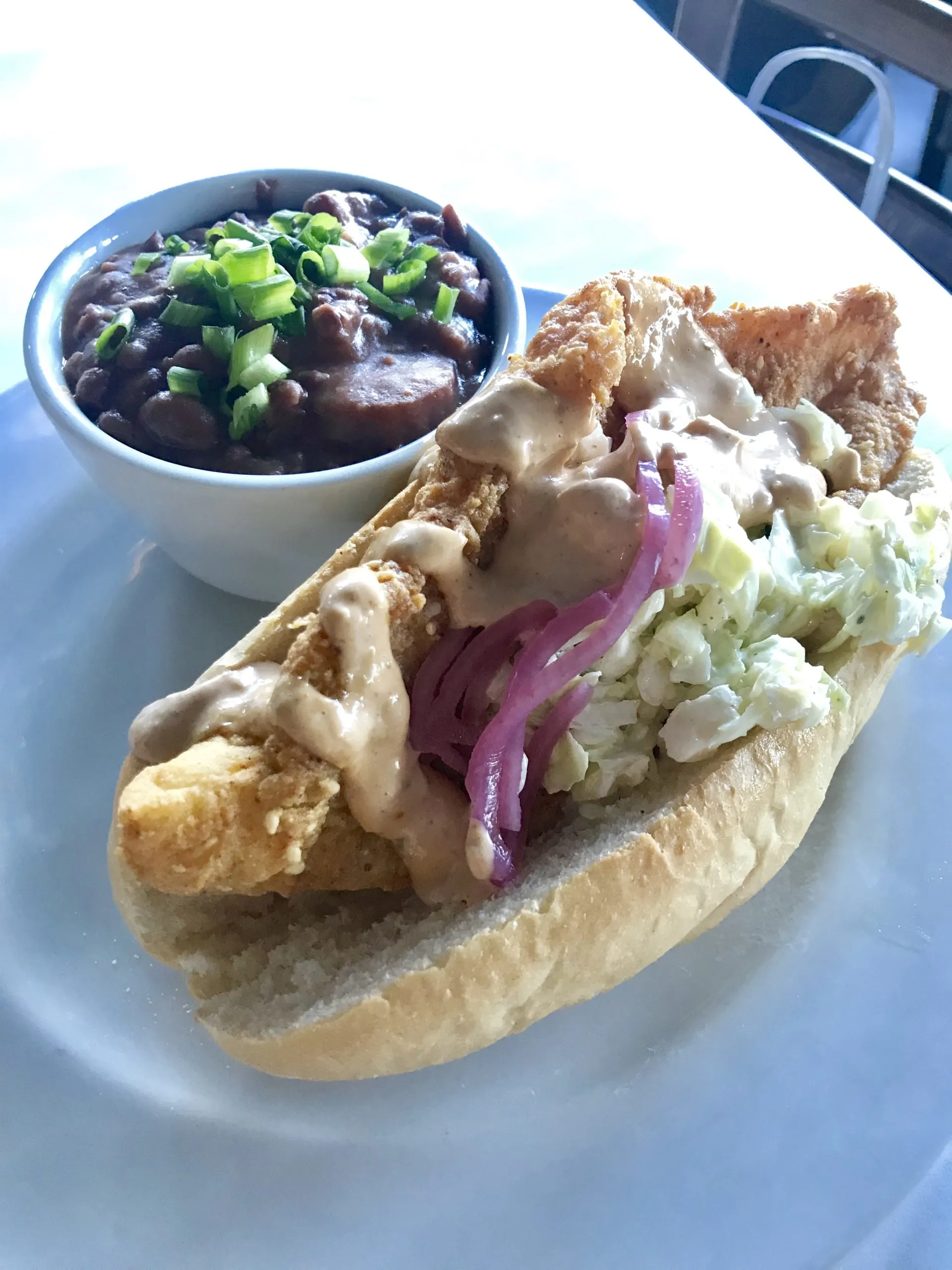 catfish po'boy sandwich and red and beans and rice on a plate