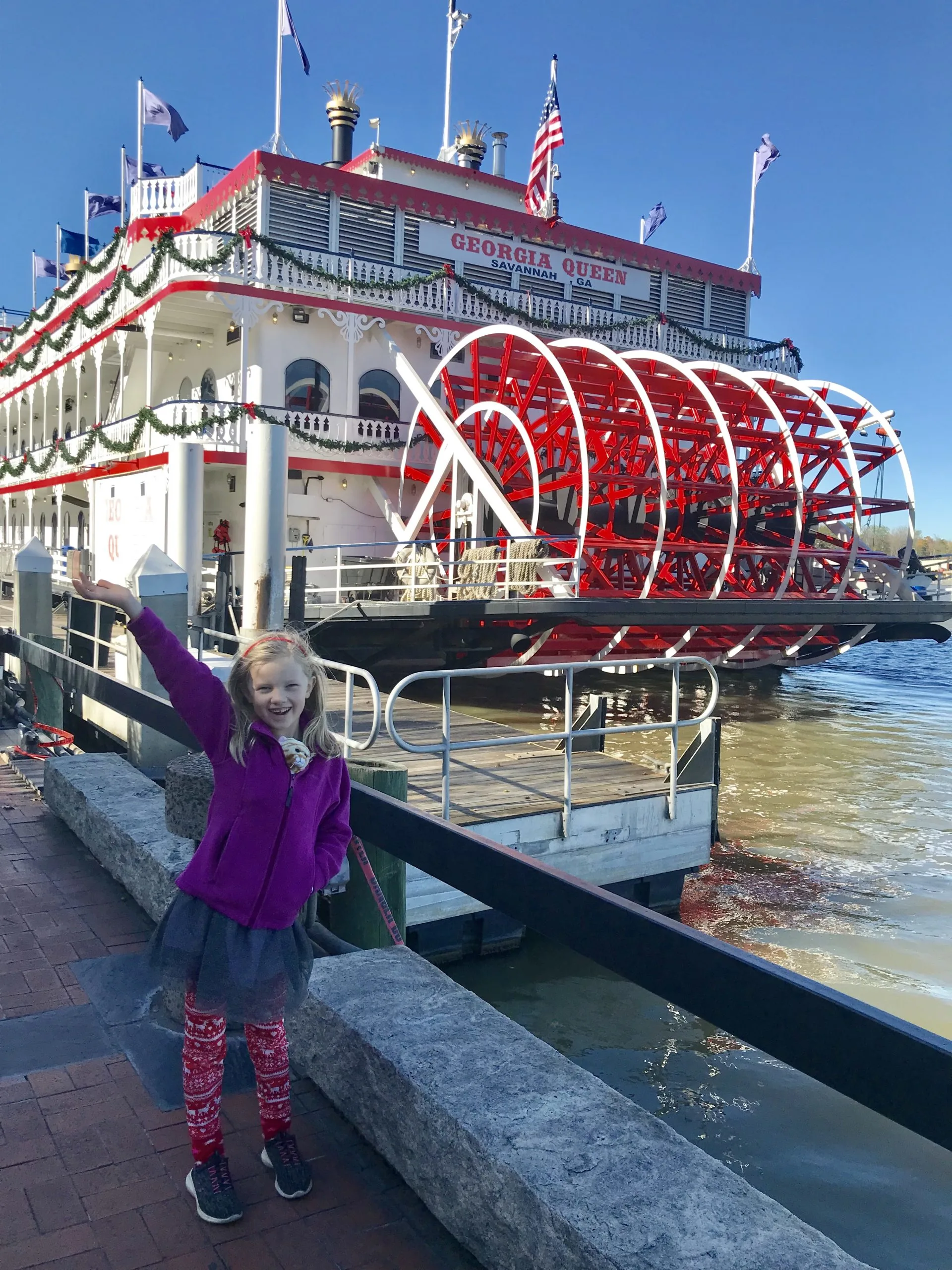 little girl in front of a ferry boat
