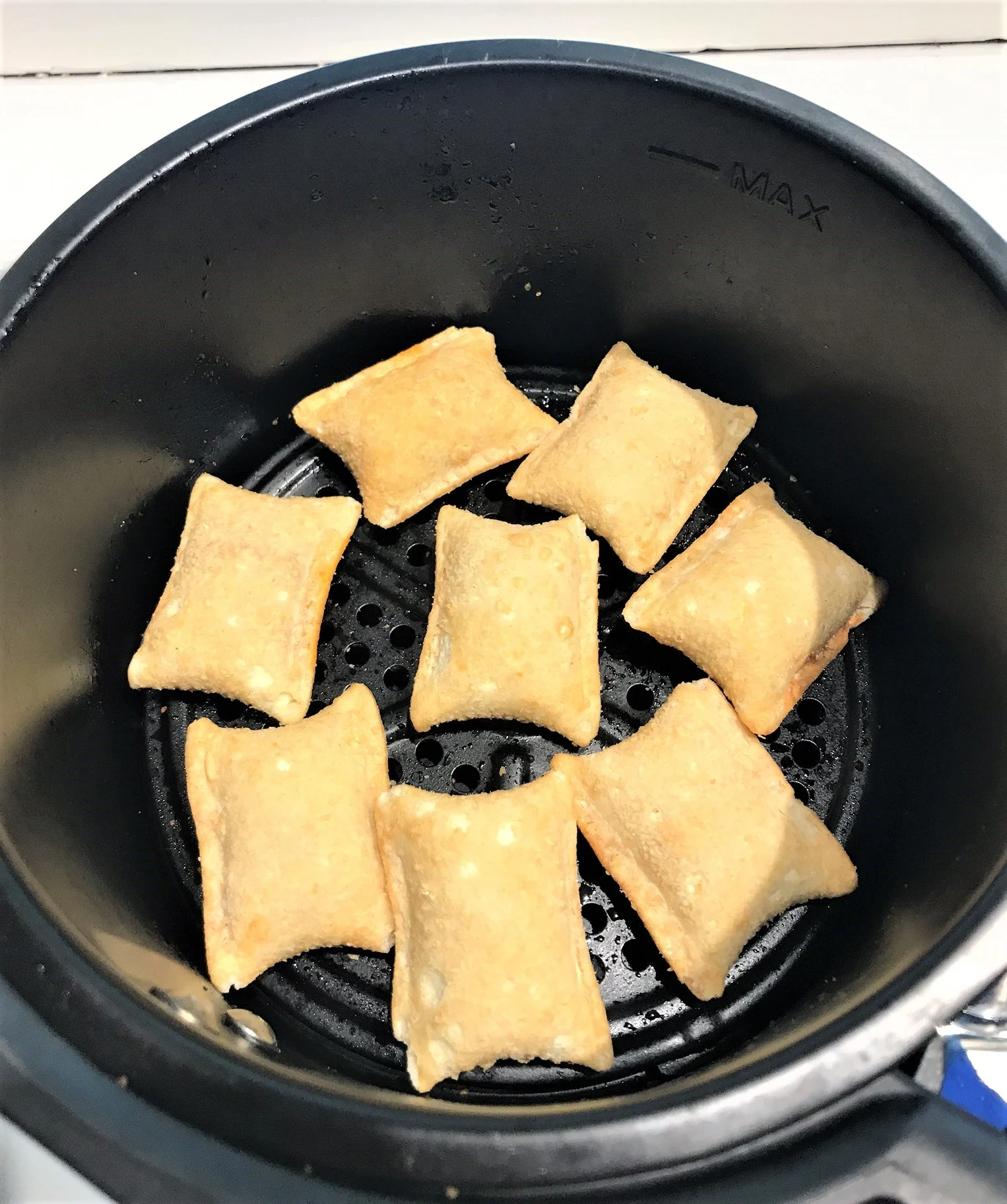 air fryer with pizza rolls arranged inside in a single layer