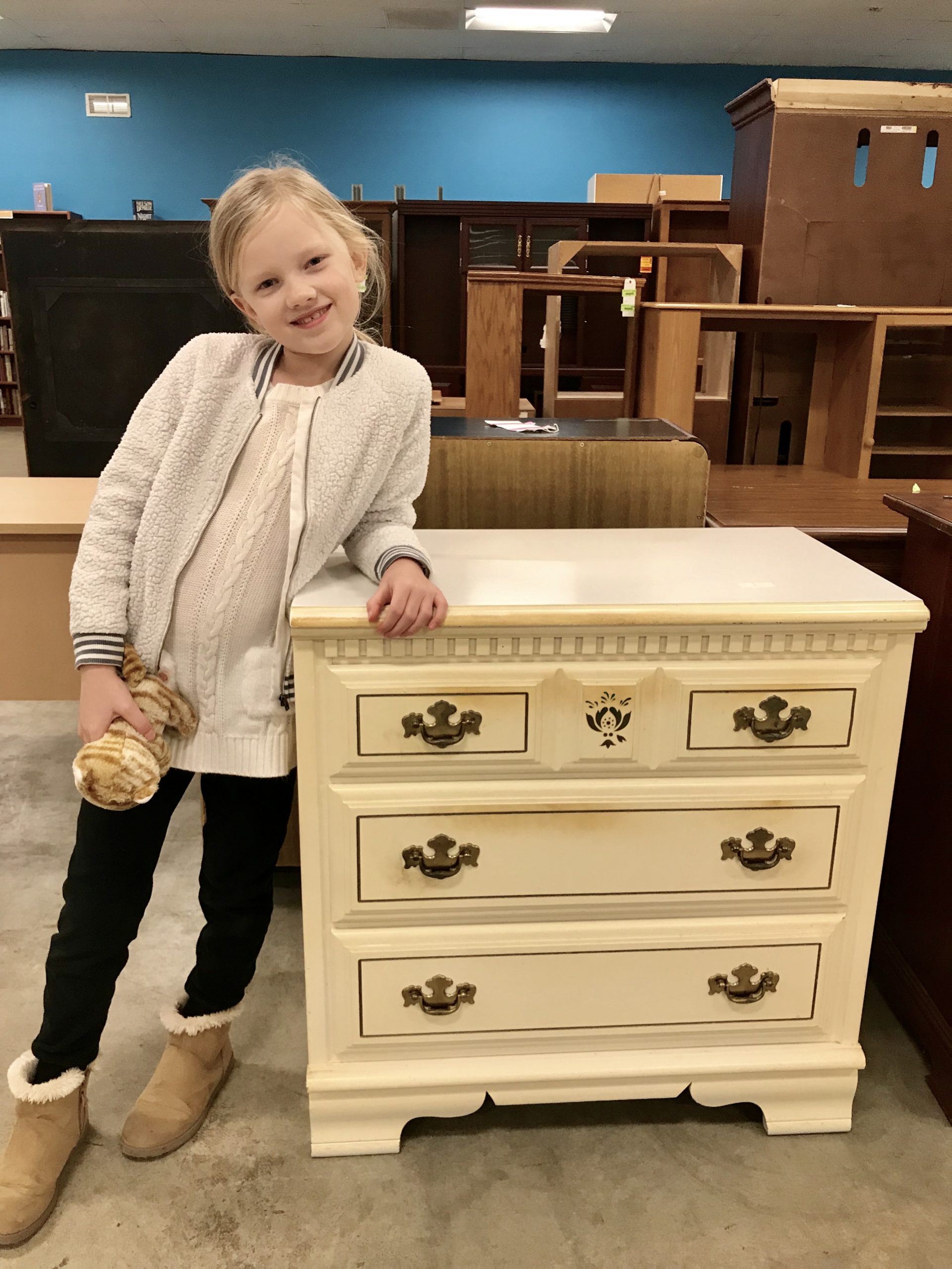 little girl standing by the chest of drawers before the makeover