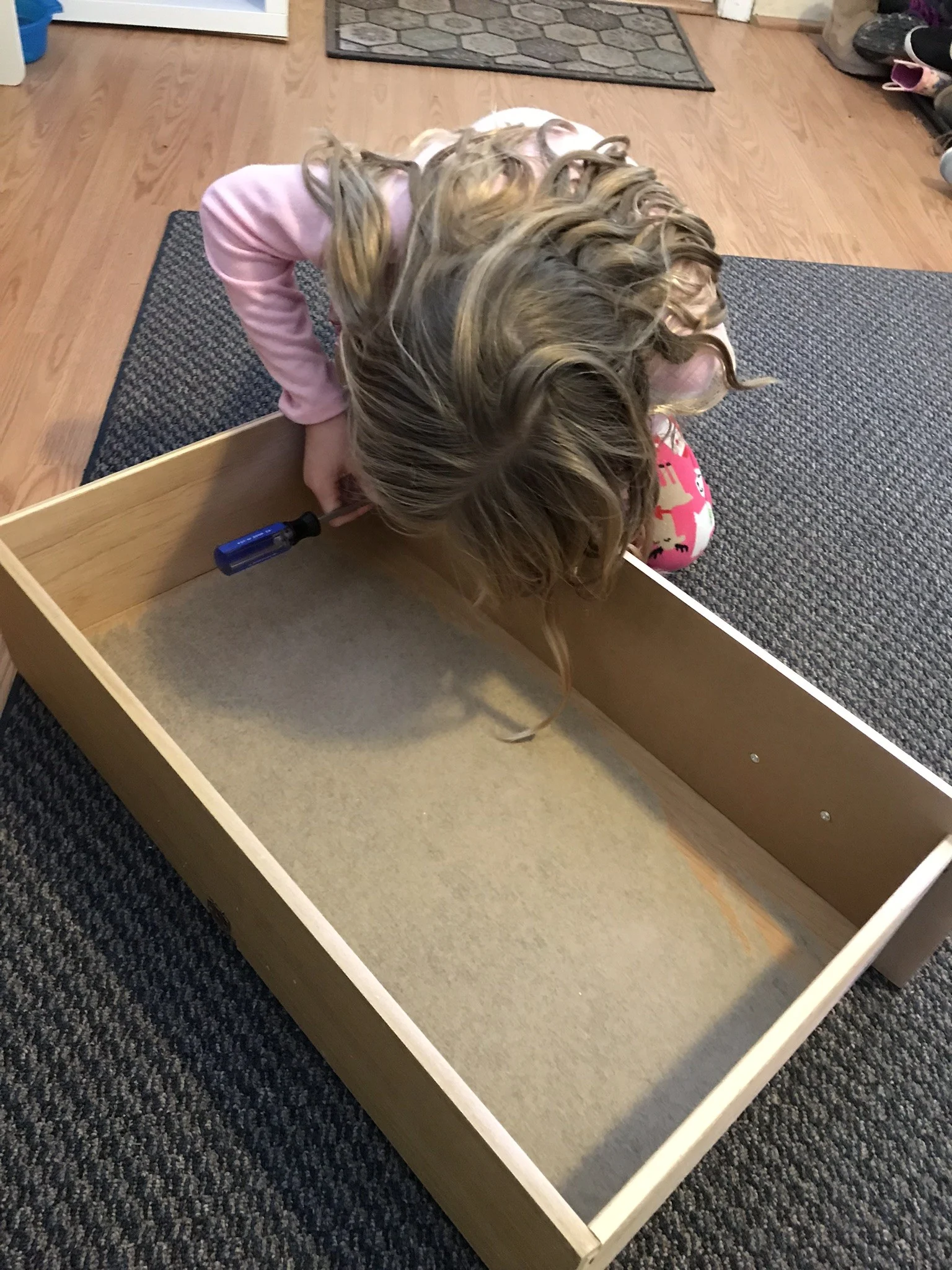 little girl installing the drawer hardware