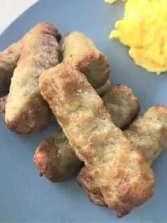 cooked sausage and scrambed eggs on blue plate