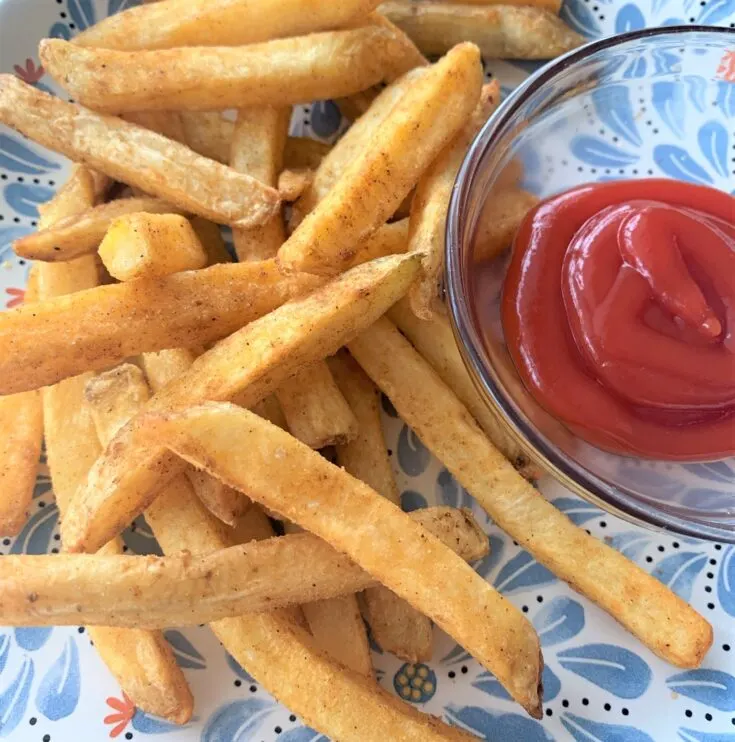 cooked air fryer french fries with bowl of ketchup