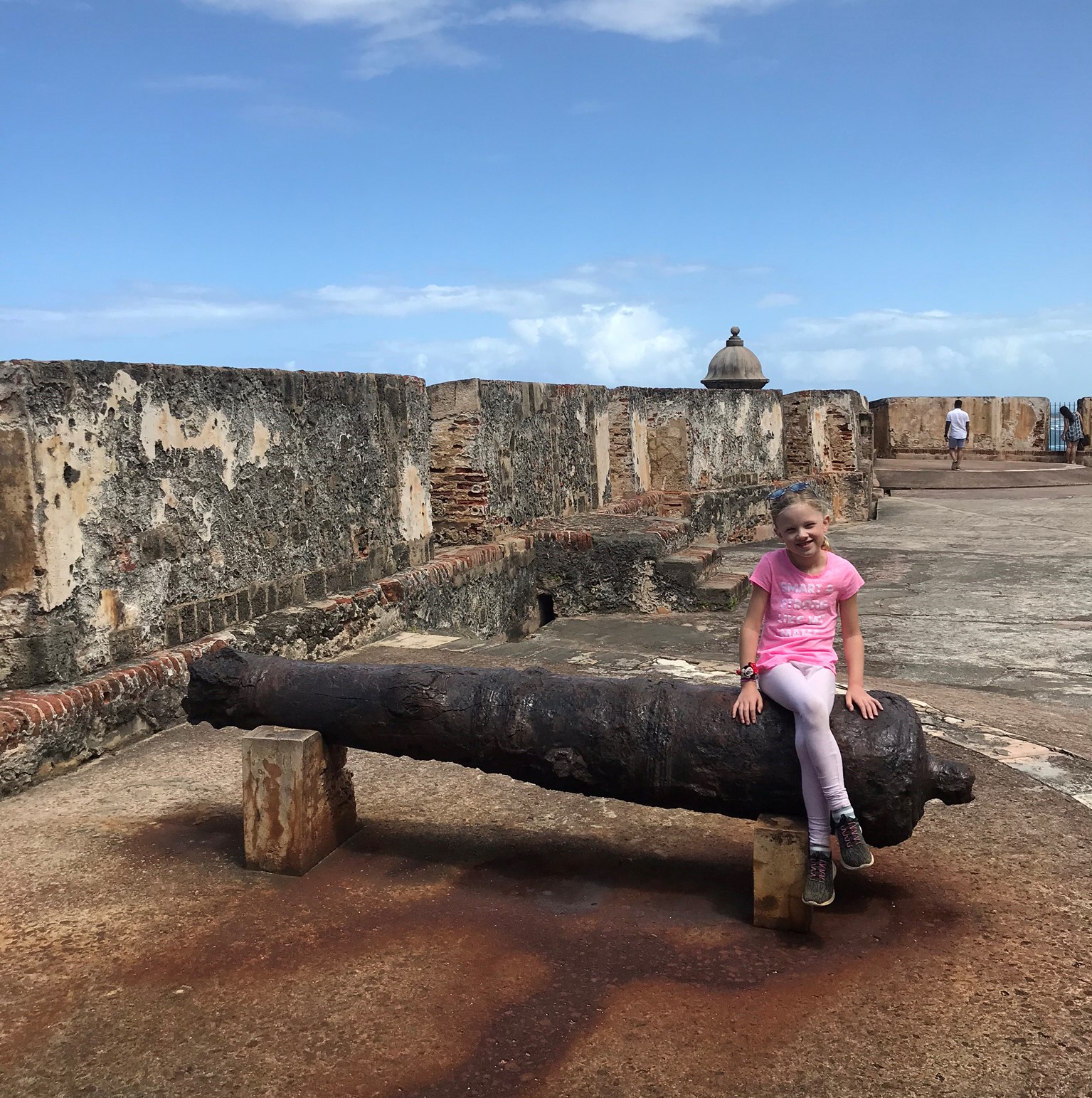 girl sitting on cannon - puerto rico with kids