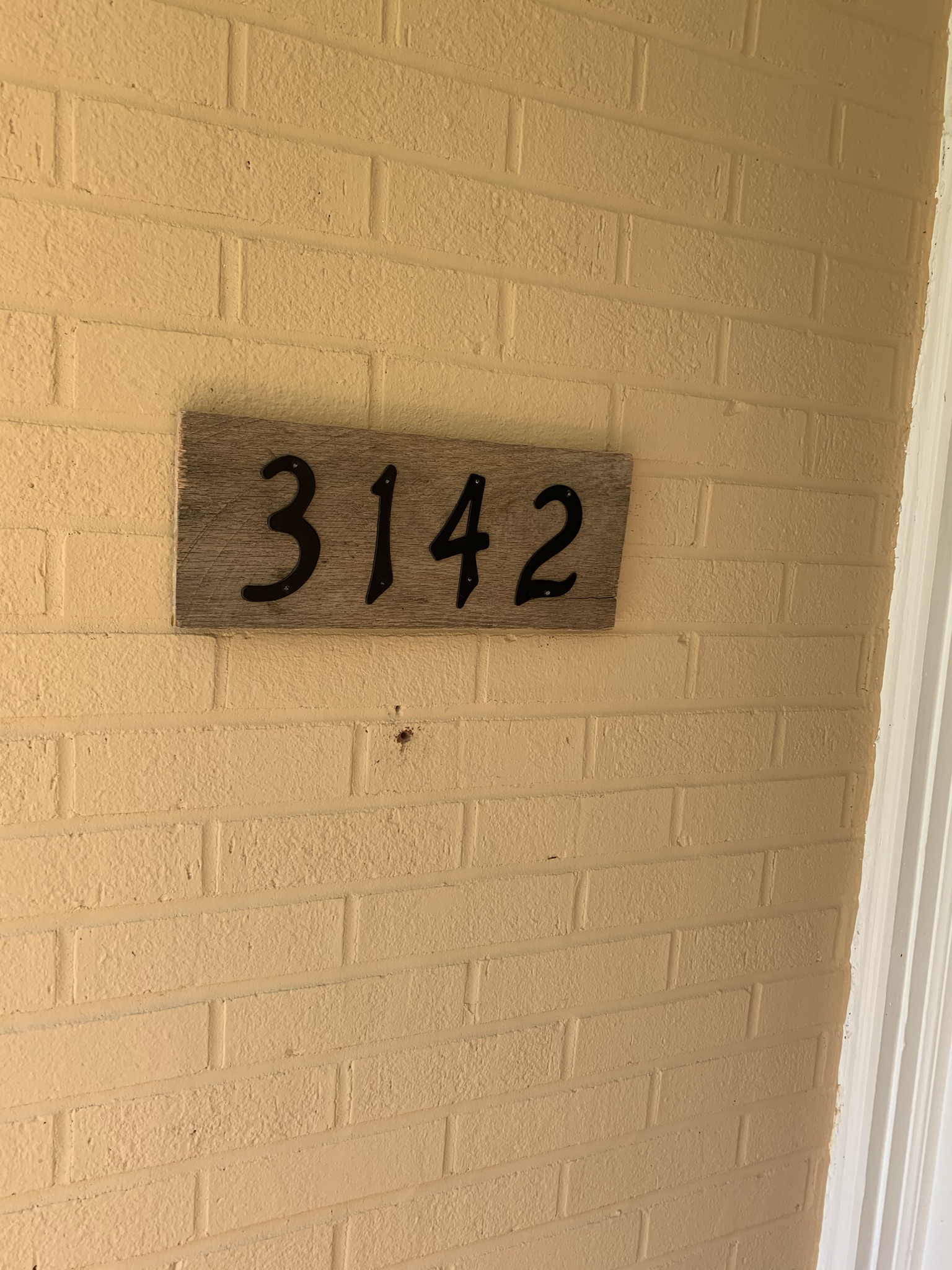 diy house number sign hung on outside brick wall