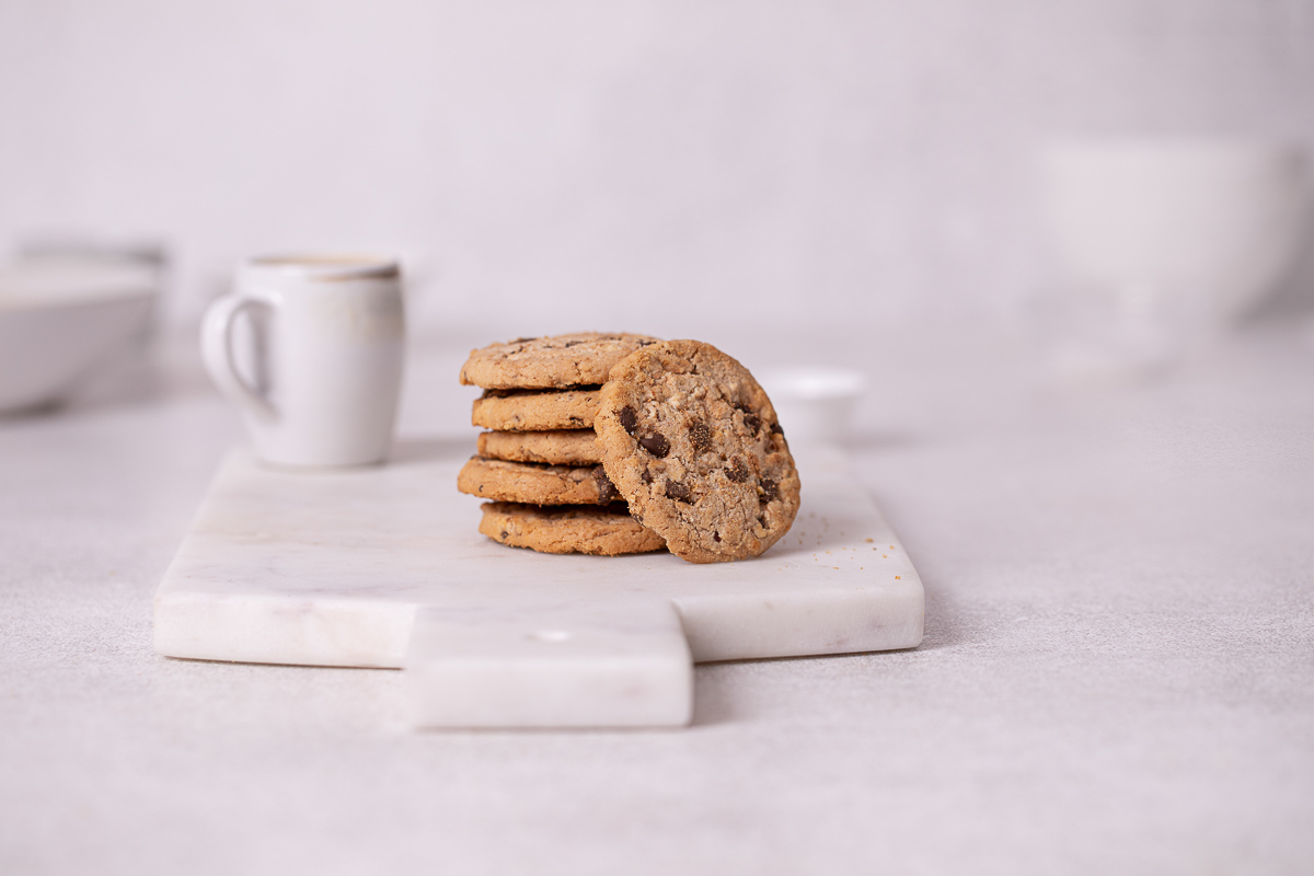 stack of cookies with coffee cup in background