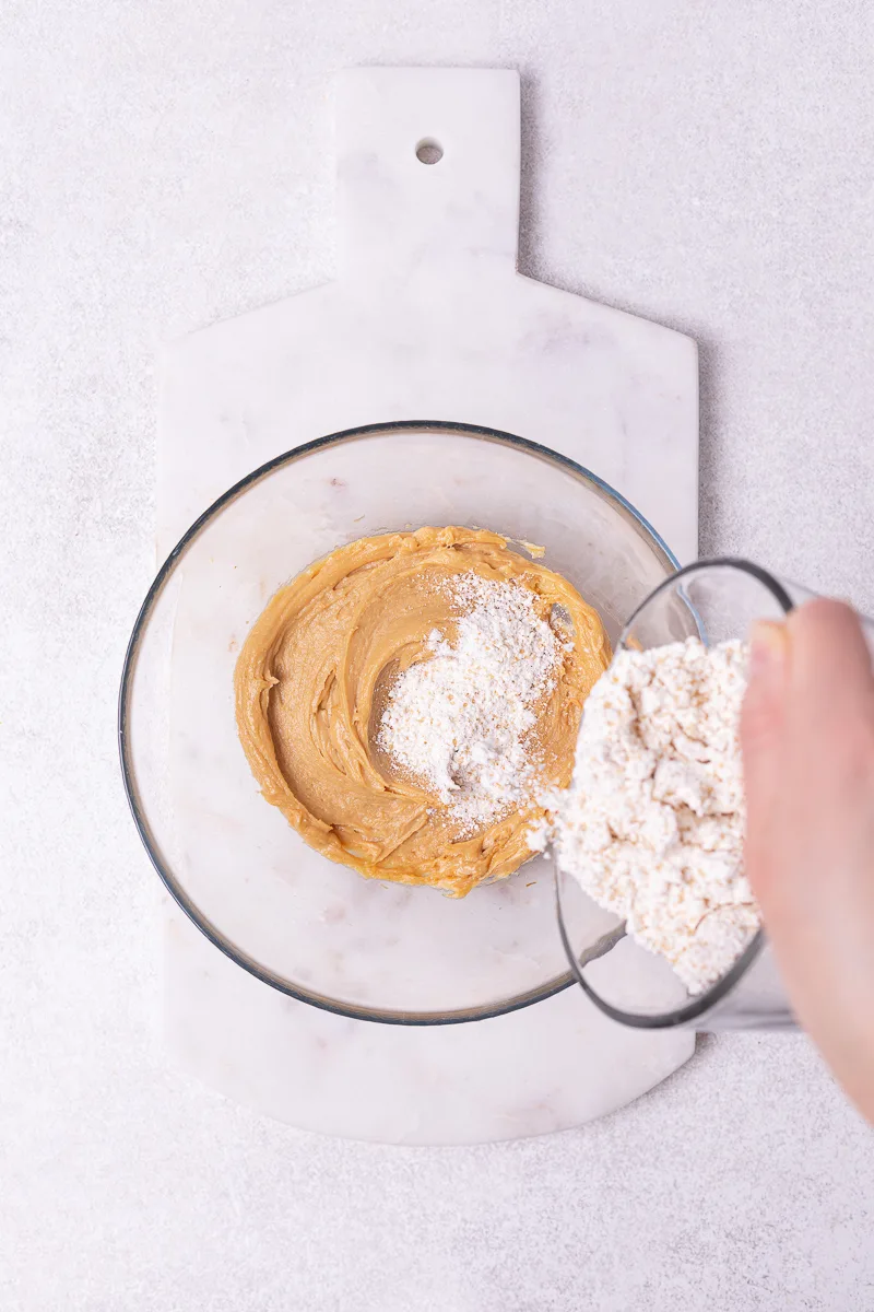 adding flour to peanute butter mix
